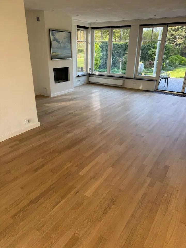 Dezelfde kamer met open haard na het schuren en een speciale lak, de vloer warm en egaal