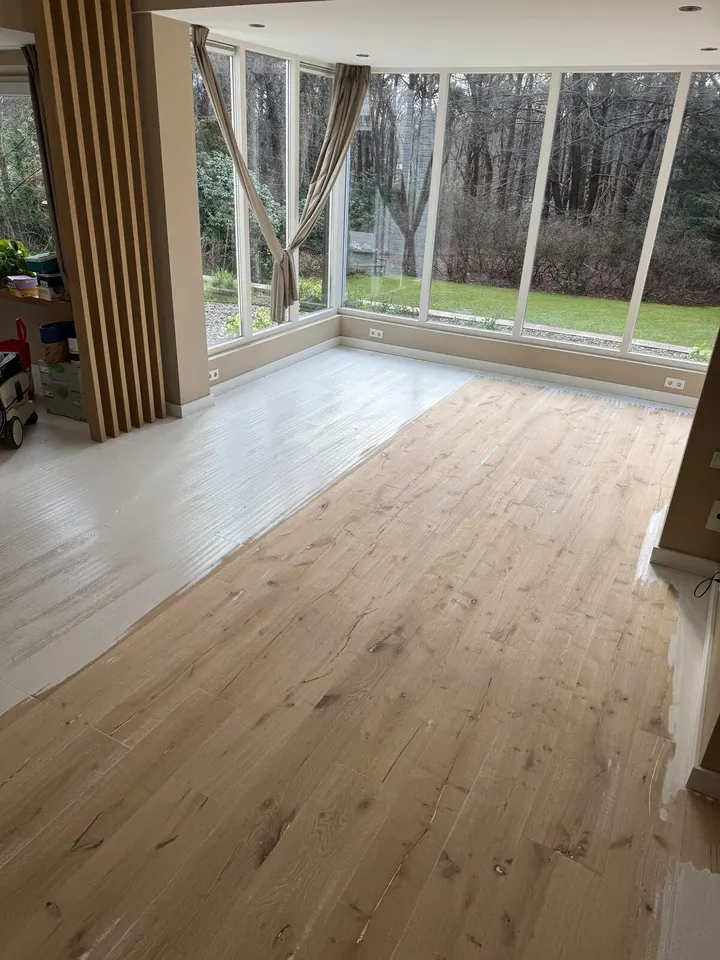 Dezelfde tuinkamer half geschuurd, kale planken aan de ene kant en de witte verf nog aan de andere