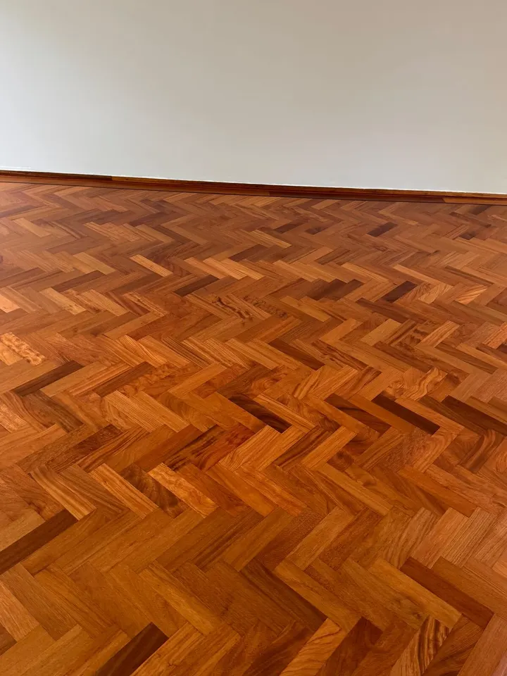 De afgewerkte visgraatblokjes van dichtbij, nerf en kleurverschillen scherp onder een glanzende afwerking
