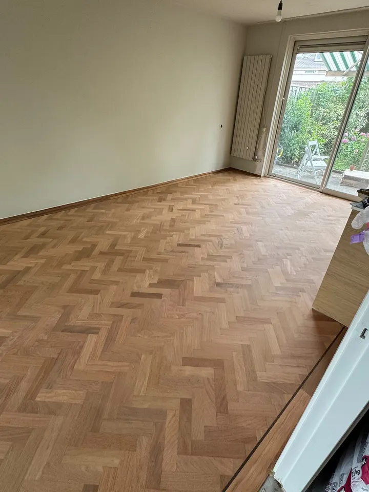 De visgraatvloer bij de schuifdeuren, teruggeschuurd tot kaal hout